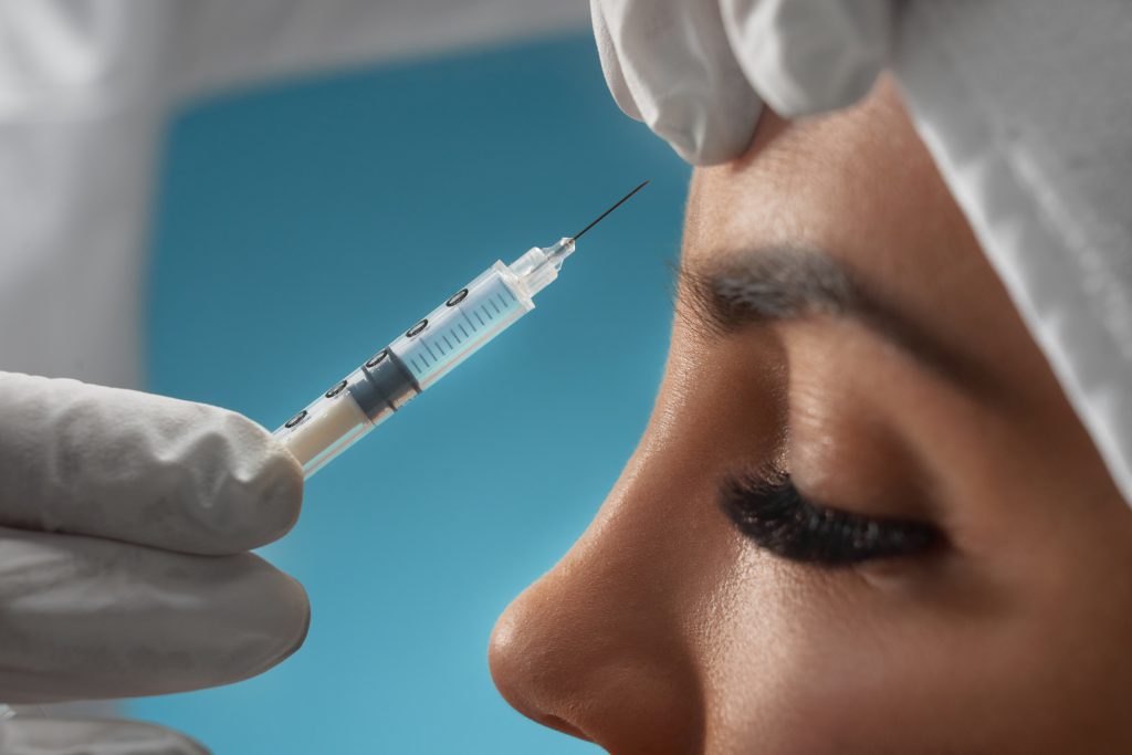 Cosmetic botox injection in female forehead.